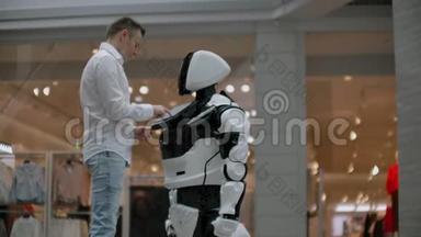 一个男人和<strong>机器</strong>人<strong>机器</strong>人站在一起，问他问题，并通过<strong>点击机器</strong>人身体上的屏幕来寻求帮助。